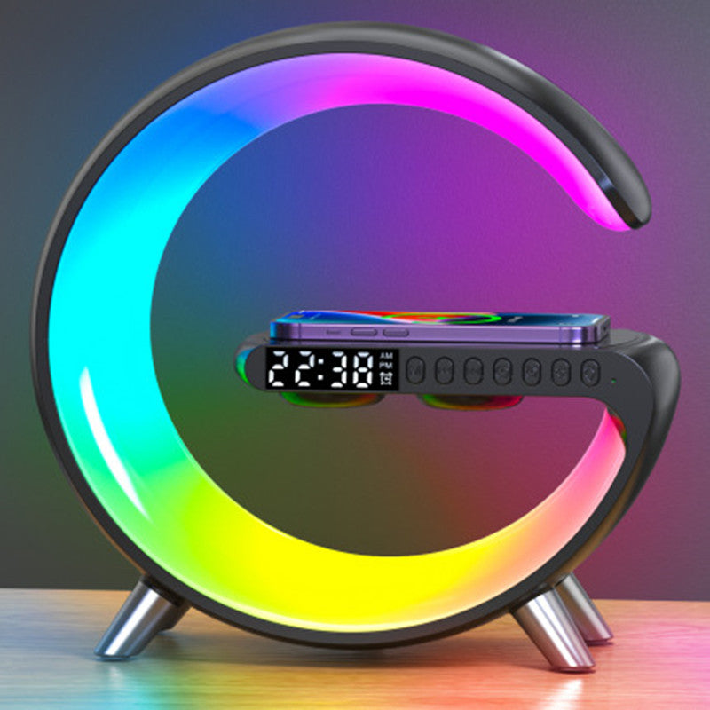 Aura G G-shaped RGB lamp glowing rainbow colors with phone on wireless charger