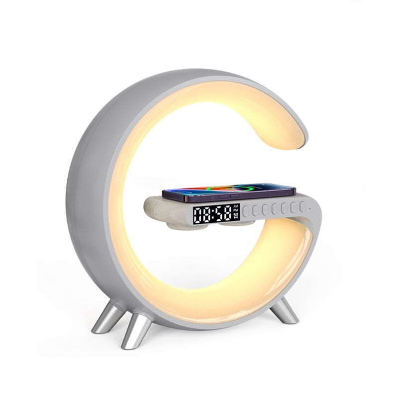 Aura G G-shaped lamp in light grey with warm white glow and phone charging